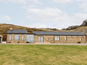 a stone house with a black roof at House Crohy Head in Dungloe