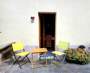 three chairs and a table in front of a building at Casa Antica Corte in Giumaglio