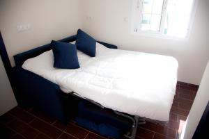 una cama con almohadas azules en una habitación en Noches en Triana, en Sevilla