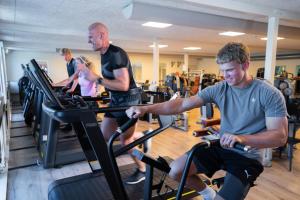 eine Gruppe von Personen, die in einem Fitnessstudio auf Laufbändern trainieren in der Unterkunft SportsPark Blaavandshuk Resort in Oksbøl