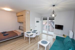ein Wohnzimmer mit einem Bett, einem Sofa und einem Tisch in der Unterkunft Urban Jungle - Space Apartment in Białystok