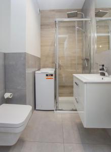 Urban Jungle - Space Apartment في بياويستوك: حمام مع دش ومرحاض ومغسلة +8 صور