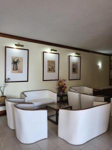 - une salle d'attente avec des tables et des chaises blanches dans l'établissement Hotel Beira Mar, à Angra do Heroísmo