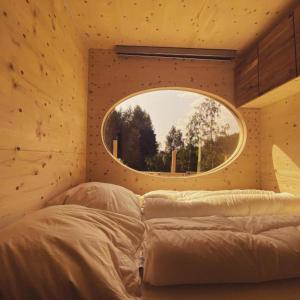 a bedroom with a circular window above a bed at Zinipi Retreat Gelenau "Eule" in Gelenau