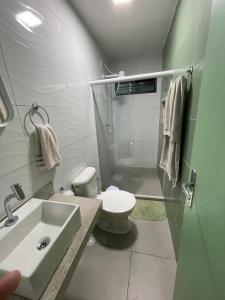 a bathroom with a shower and a toilet and a sink at Casa verde no Pontal de Maracaipe in Porto De Galinhas