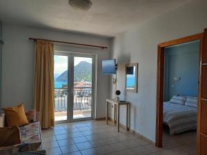 a bedroom with a bed and a sliding glass door at Ntemos Apartments in Tolo