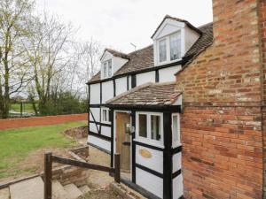 una casa en blanco y negro con un edificio de ladrillo en Rose Cottage, en Upton upon Severn