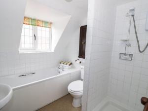 a white bathroom with a tub and a toilet and a sink at Rose Cottage in Upton upon Severn +17 photos