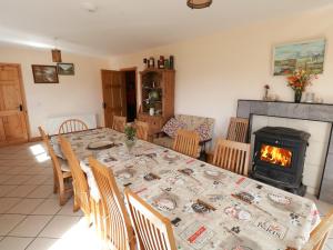 a dining room with a table and a fireplace at Lough Mask Road Fishing Lodge in Cong