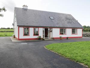 a white and red house with a driveway at Lough Mask Road Fishing Lodge in Cong