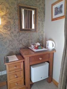 a wooden desk with a mirror on a wall at Hazelwood Farm B&B in Easingwold