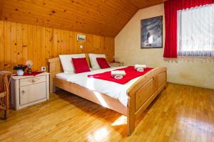 a bedroom with a large bed with red sheets at Farm Stay Trlej in Begunje na Gorenjskem