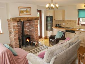 a living room with a fireplace and a couch at Minton Lane Cottage in Church Stretton