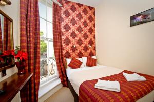 Habitación de hotel con cama y ventana en Leigh House Hotel en Londres