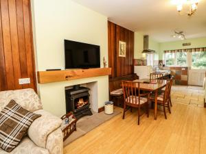 a living room with a table and a fireplace at Holly Lodge in Appleby
