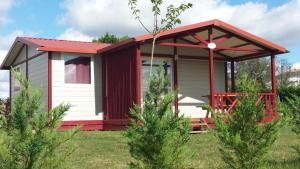 eine rot-weiße Hütte mit rotem Dach in der Unterkunft Chalet -Glory- in Casteljaloux