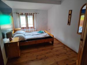 a bedroom with a bed and a window and a wooden floor at Agroturystyka UL in Nowe Worowo