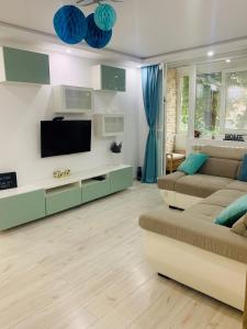 ein Wohnzimmer mit einem Sofa und einem Flachbild-TV in der Unterkunft Perfect, relaxing and cozy apartment in Timişoara