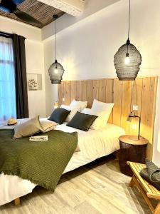 a bedroom with a large bed and two pendant lights at Le S in Argelès-sur-Mer