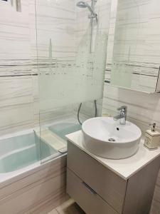 ein weißes Badezimmer mit einem Waschbecken und einer Badewanne in der Unterkunft Perfect, relaxing and cozy apartment in Timişoara
