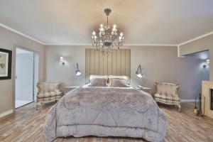a bedroom with a large bed and a chandelier at Villa Casato Residenza Boutique in Campos do Jordão
