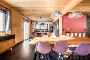 uma sala de jantar com uma mesa de madeira e cadeiras roxas em Chalet Azobe Morzine - by EMERALD STAY em Montriond