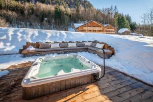 una bañera de hidromasaje en una terraza en la nieve en Chalet Azobe Morzine - by EMERALD STAY, en Montriond