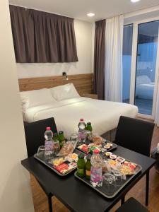una camera d'albergo con letto e tavolo con cibo di Grandi 32 a Segrate