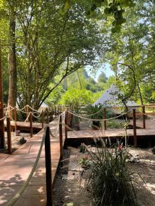 a wooden walkway in a garden with a fence at River Tribe Glamping in Laino Borgo