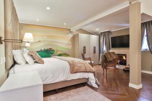 a bedroom with a large bed and a fireplace at Villa Casato Residenza Boutique in Campos do Jordão