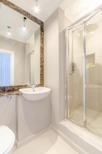 a white bathroom with a sink and a shower at ALTIDO Elegant 2-bed, 2 bath flat with private terrace in South Kensington, close to tube in London