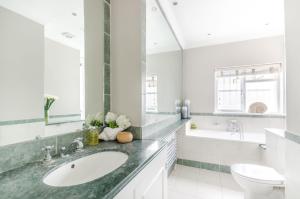 a white bathroom with a sink and a toilet at ALTIDO Elegant 2-bed, 2 bath flat with private terrace in South Kensington, close to tube in London
