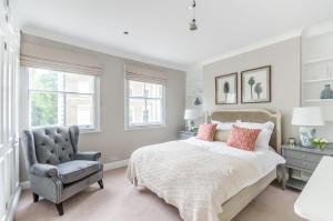 a bedroom with a bed and a chair at ALTIDO Elegant 2-bed, 2 bath flat with private terrace in South Kensington, close to tube in London
