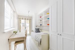 a bedroom with a bed and a desk and a table at ALTIDO Elegant 2-bed, 2 bath flat with private terrace in South Kensington, close to tube in London