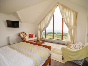 a bedroom with a bed and a large window at Millers Lane House in Aught Upper