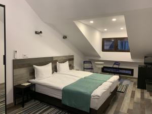 um quarto com uma cama e duas cadeiras em ARTE Hotel rooms & apartments em Veliko Tŭrnovo