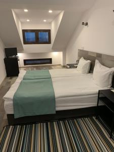 um quarto com uma grande cama branca e um tapete em ARTE Hotel rooms & apartments em Veliko Tŭrnovo