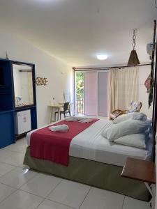 a bedroom with a large bed and a window at Pousada Barra Velha in Maragogi