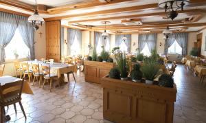 une salle à manger avec des tables, des chaises et des plantes en pot dans l'établissement Landhaus Rhönblick, à Künzell