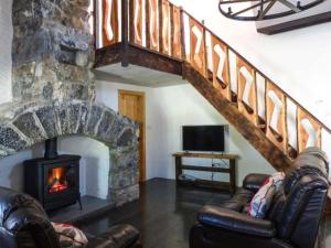 a living room with a stone staircase and a fireplace at The Well House in Kinvara