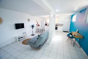 Chez Rey في Médecin: غرفة معيشة بيضاء وزرقاء مع أريكة