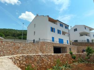 a large white building behind a stone wall at Gavan Room in Cres