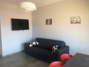 a living room with a couch and a flat screen tv at Il Cubo di Anja in Pisogne