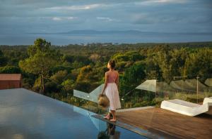 Eine Frau, die am Pool steht in der Unterkunft Eco-lodge Villa Epicurea in Sesimbra
