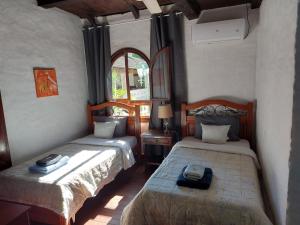 1 dormitorio con 2 camas y ventana en Mein Land Paraguay - Bed & Breakfast, en Independencia