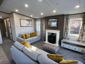 a living room with a couch and a fireplace at Blue Bell Lodge with Hot Tub Malton in Little Habton