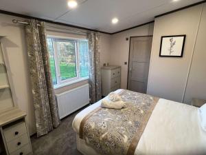 a bedroom with a bed and a window at Blue Bell Lodge with Hot Tub Malton in Little Habton +6 photos