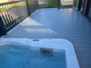 a jacuzzi tub on the deck of a house at Blue Bell Lodge with Hot Tub Malton in Little Habton