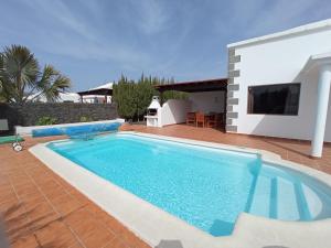 a swimming pool in front of a house at VILLA MARTA in Playa Blanca