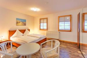 a bedroom with a bed and a table and chairs at Ferienwohnung Warnemünde in Warnemünde